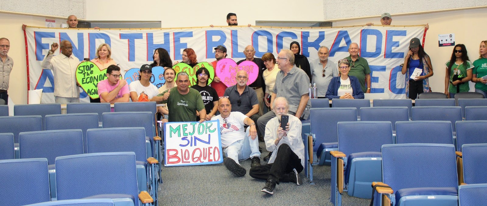 Group photo picture of Cuba Solidarity Activists with a sign that reads END THE BLOCKADE AGAINST CUBA